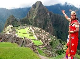 Vista panorâmica da antiga cidadela de Machu Picchu aninhada entre montanhas verdes sob um céu claro, destacando a beleza do local durante a Machu Picchu melhor época.
