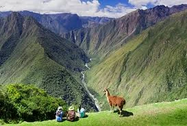 Caminhantes em uma seção antiga e rochosa da Trilha Inca, com vistas deslumbrantes da paisagem montanhosa, evidenciando por que a Machu Picchu melhor época é ideal para esta aventura.
